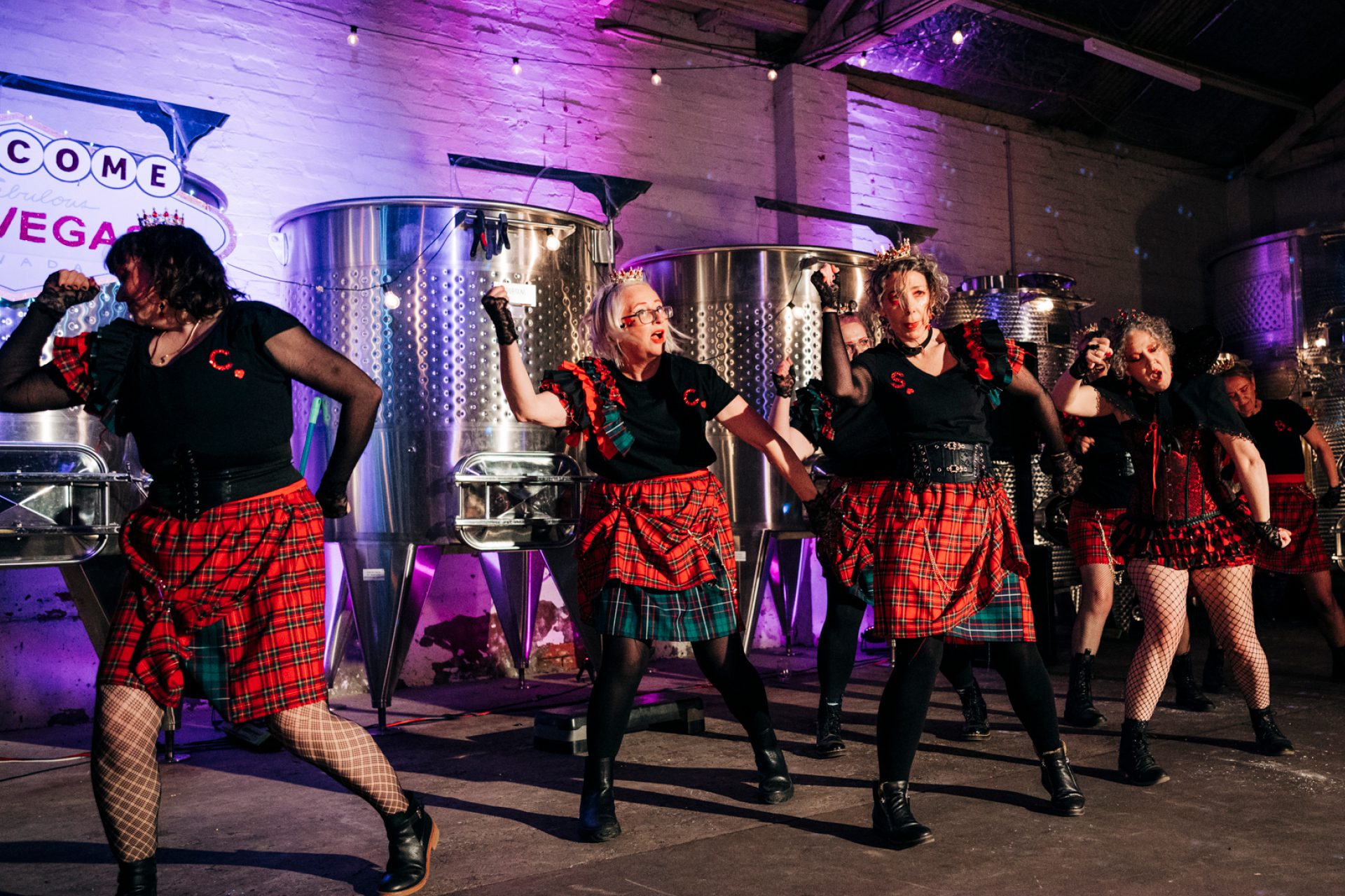 Woman in black and white top dancing with hands helup and eyes closed